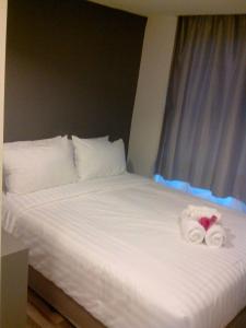 1 cama con 2 toallas y 2 toallas en Nantra Ploenchit hotel, en Bangkok