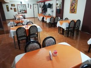 Hotel Alexander في ميندوزا: مطعم فيه طاولات وكراسي في الغرفة