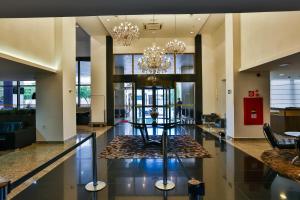 a lobby with a chandelier and a table at SJ Premium Hotels By Atlantica in Goiânia