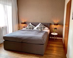a bedroom with a bed with two pillows on it at Hotel Akazienhof in Duisburg