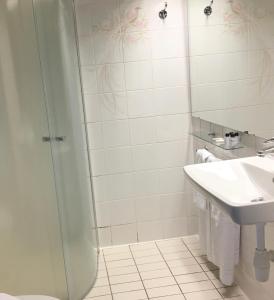 a bathroom with a shower and a sink at Hotel Småland in Skillingaryd