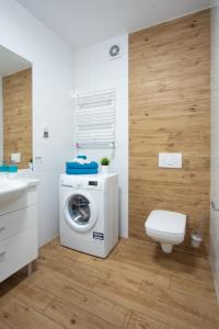 La salle de bains est pourvue d'un lave-linge et de toilettes. dans l'établissement Apartamenty Morski Florek, à Kołobrzeg