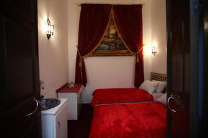 a bedroom with two beds with red sheets and a window at Dar Essaki 1886 in Tangier