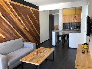 a living room with a couch and a table and a kitchen at Casa Maye in Oaxaca City