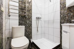 a white bathroom with a toilet and a shower at Baker's street in Lviv +10 photos