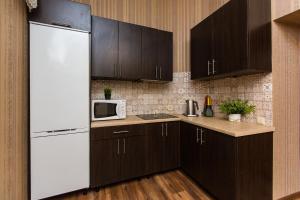 a kitchen with brown cabinets and a white refrigerator at Baker's street in Lviv