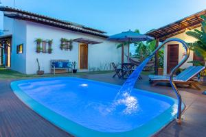 a pool with a water slide in front of a house at Casa Hibiscus Beach Club Ipioca Maceió in Maceió