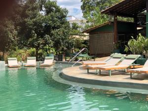 uma piscina com espreguiçadeiras e um escorrega aquático em Casa da Lua Pousada em Alto Paraíso de Goiás