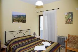 een slaapkamer met een bed, een stoel en een raam bij House Evia in Strópones