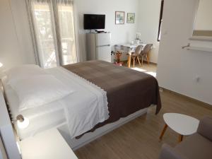 een slaapkamer met een bed en een tafel met stoelen bij Apartments Simicev in Zadar