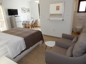 a bedroom with a bed and a couch and a table at Apartments Simicev in Zadar