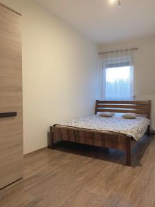 a bedroom with a bed in a room with a window at St. Péter Apartman in Pécs