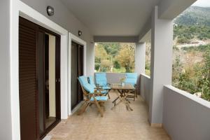 een patio met blauwe stoelen en een tafel op een balkon bij House Evia in Strópones