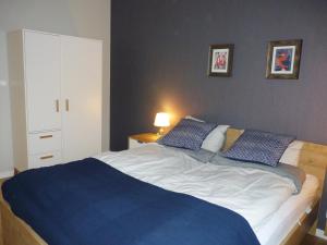 a bedroom with a large bed with two blue pillows at Apartament z liskiem in Szczyrk