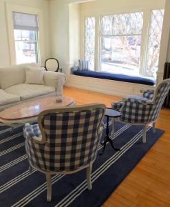 ein Wohnzimmer mit einem Sofa, einem Tisch und Stühlen in der Unterkunft The Belmont Inn in Camden