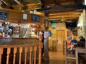 a woman sitting at a bar in a restaurant at Albergue El Puntido in Hontanas