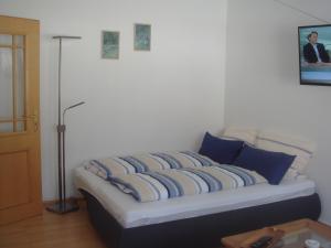 a bed with blue and white pillows in a room at Ferienwohnung Rutenberg in Bremerhaven