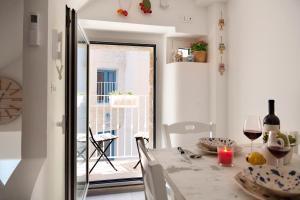 una sala da pranzo con tavolo e porta in vetro di Il Balconcino nel Vicolo Short Lets a Polignano a Mare