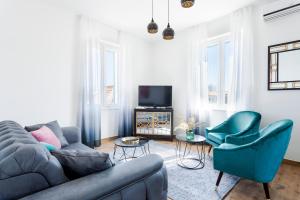 un soggiorno con divano, sedie e TV di Cozy Apartment Lile in the heart of old town Split a Spalato (Split)