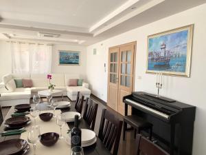 a dining room with a table and a piano at Villa Mia in Marina