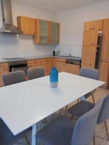 una cocina con una mesa blanca con jarrón azul. en Gemütliches 3 Zimmer Apartment nahe Graz, en Gratkorn