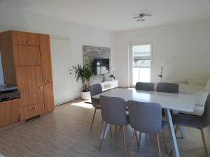 cocina y comedor con mesa blanca y sillas en Gemütliches 3 Zimmer Apartment nahe Graz, en Gratkorn