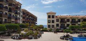 a view of two apartment buildings and a swimming pool at Balcon Del Mar Luxury Suite in Costa Del Silencio