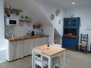a kitchen with a table and a blue cabinet at Casas do Ardila in Santo Amador