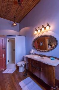 uma casa de banho com um lavatório, um WC e um espelho. em Upstairs Inn em Hico