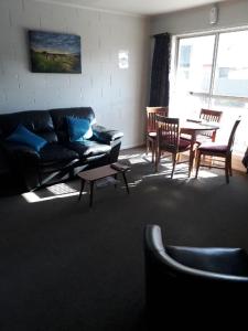 ein Wohnzimmer mit einem Sofa und einem Tisch in der Unterkunft Aalton Motel Temuka in Temuka