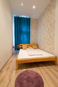 1 dormitorio con 1 cama y una ventana con cortinas azules en Standard Apartment by Hi5 - West End Center, en Budapest