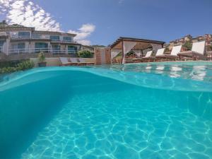 a large swimming pool with blue water at Hotel Experience João Fernandes in Búzios