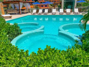 a swimming pool with blue water in a resort at Hotel Experience João Fernandes in Búzios