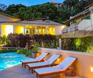 a villa with a swimming pool at night at Hotel Pousada Experience João Fernandes in Búzios