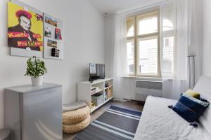 ein weißes Wohnzimmer mit einem Sofa und einem Fenster in der Unterkunft JT's Apartments Navrátilova str. in Prag