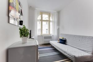 ein Wohnzimmer mit einem Sofa und einem Fenster in der Unterkunft JT's Apartments Navrátilova str. in Prag