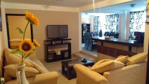 a living room with a vase with a sunflower at Villa Victoria Pirámides in San Martín de las Pirámides