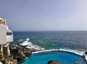 una piscina en el océano junto a un edificio en queen’s paradise, en Callao Salvaje