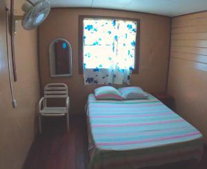 
a bedroom with a bed and a window at Hotel Maritza in Puerto Viejo
