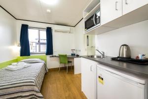 a small room with a bed and a kitchen at Jolly Swagman Acccommodation Park in Toowoomba