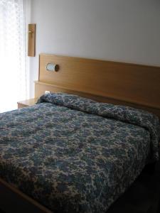 a bedroom with a bed with a wooden head board at Bellavista B&B in Cavedago