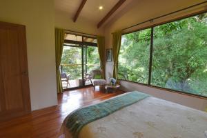 a bedroom with a bed and a large window at Monteverde Casa Mia, near main attractions and town! in Monteverde Costa Rica