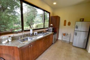 a kitchen with a sink and a refrigerator and a window at Monteverde Casa Mia, near main attractions and town! in Monteverde Costa Rica +62 photos