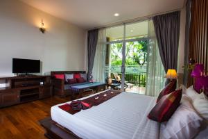 ein Schlafzimmer mit großem Bett und Fernseher in der Unterkunft Pattra Vill Resort in Lamai