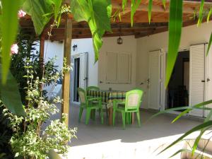 a patio with a table and green chairs at NIKOS in Kakovatos