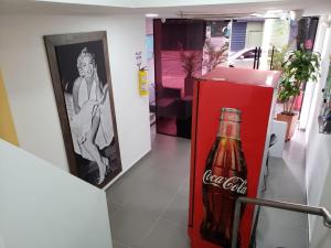 una botella de cocacola sentada junto a una nevera roja en Hotel zona express sandiego, en Medellín