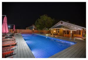 a swimming pool at night with chairs around it at Ruby True Hotel in Bagan