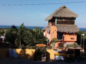 a large building with a straw roof at Casa Gio in Puerto Escondido