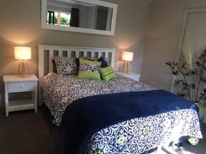 a bedroom with a bed with pillows and two lamps at Highlands on Homestead in Oamaru