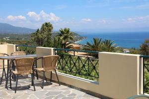 a balcony with a table and chairs and the ocean at ORFANOS 3 in Armenoí